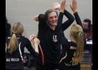 Freshman Taylor Hamilton (M) celebrates with teammates Allison Asfeld (L) and Olivia Irsfeld (R) after scoring a point during B/EV’s comeback win over Swanville.